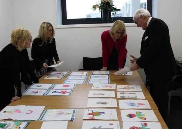 John Sanson pictured with Sandra Nolan, the manager of Clarks, Diana Rimmer, sales manager of Debenhams and Wigan Evening Post editor Janet Wilson  judging the Design A Mascot entries