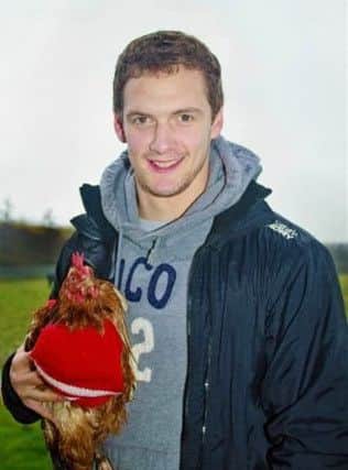 Wigan Warriors captain Sean O'Loughlin with rescued battery hen Edna in her cherry and white top during a visit to Lucky Hens Rescue