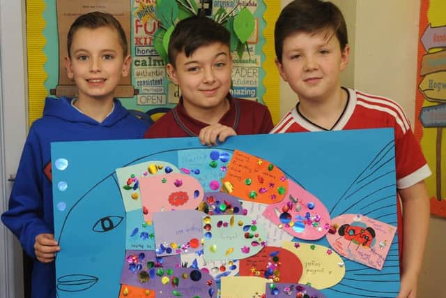 Logan's friends Harley, Regan and Jamie with a giant fish made up of 'friendship scales' relating to Logan