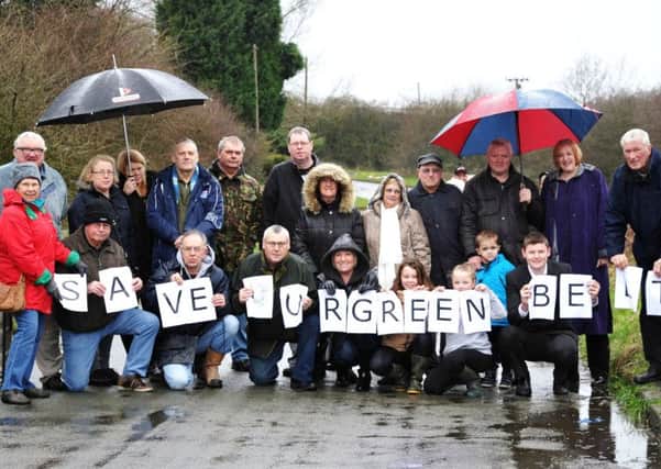 People opposed to the proposals brave heavy rain to protest on Drummers Lane in Ashton