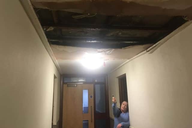 Derby House resident Beatrice Graham at the damaged roof above her flat