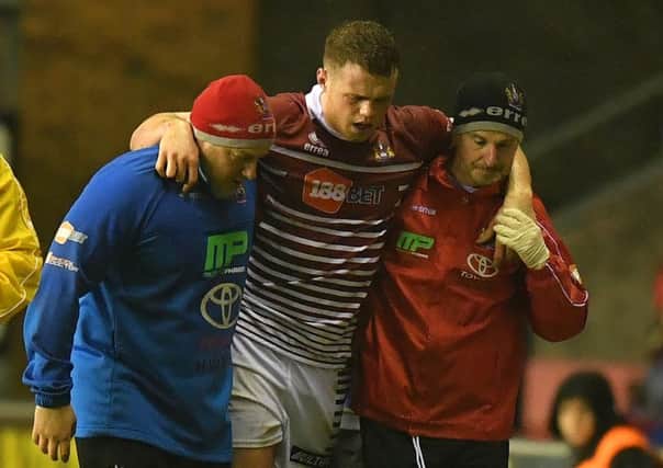 Joe Burgess is helped off the pitch