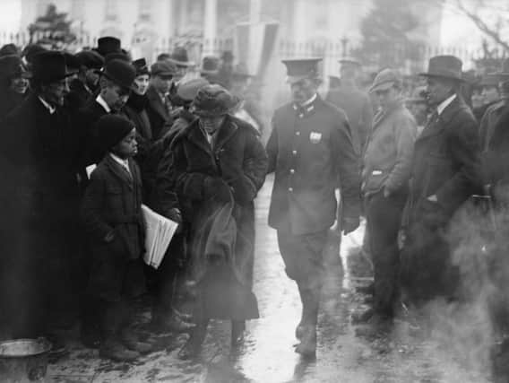 A policeman leads an arrested National Woman's Party protester away from a woman's suffrage bonfire demonstration at the White House in 1918