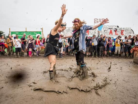 Joanna Redman, 23, and Beth Goodenough, 24, jump in the mud at Glastonbury Festival