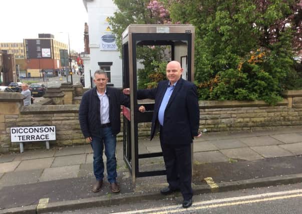 Coun Lol Hunt and Coun Michael McLoughlin at one of the vandalised phone boxes in Swinley