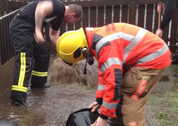 Firefighters in Nicola Storeys back garden in St Elizabeths Road, Aspull, which flooded four times in four weeks