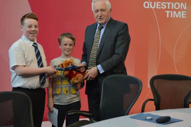 Members Jacob and Isaac Higham present David with a Wigan Youth Zone bear
