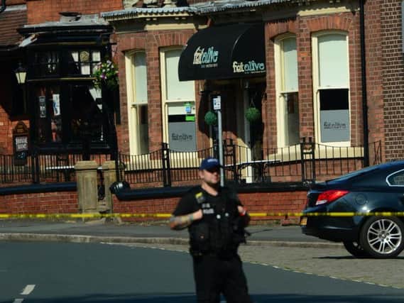 A police officer on patrol outside the Fat Olive restaurant