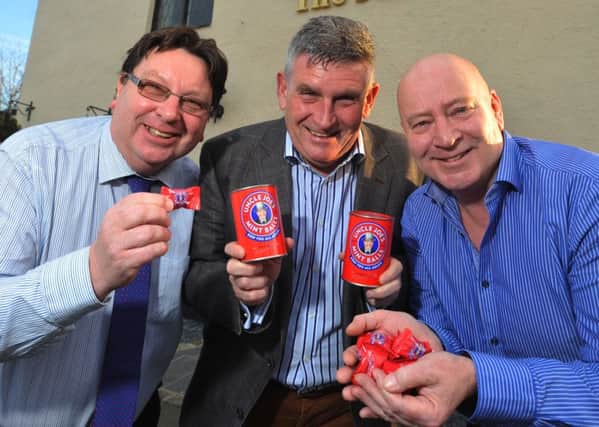 Uncle Joe's Mint Balls have new wrapping as joint managing directors John Winnard, left, and Antony Winnard, right, trial  the new design with pub owner Tony Callaghan, centre