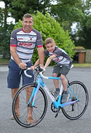 Andy and Jack Johnson with a bike donated by a Paralympian which members of the Joining Jack team in the Wigan Bike Ride have the chance to win