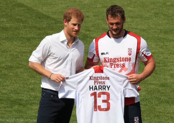 Prince Harry is presented with a personalised shirt by Sean O'Loughlin