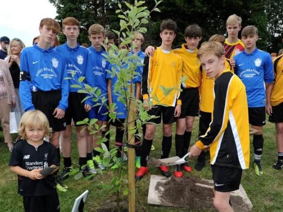 Louis's brother Isaac Anders (left) and Oliver Spencer, from his school Merchant Taylors, watched by other class mates and football pals, at the tree planting ceremony