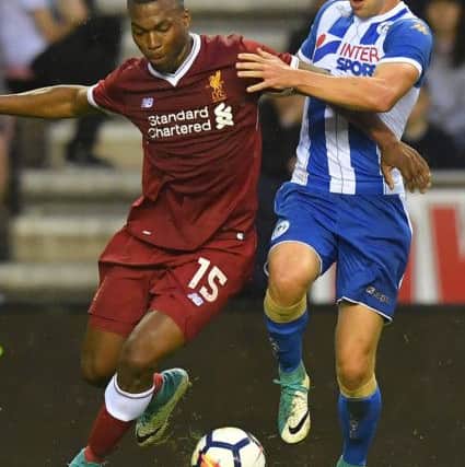 Liverpool's Daniel Sturridge is tackled during the pre-season friendly at the DW Stadium