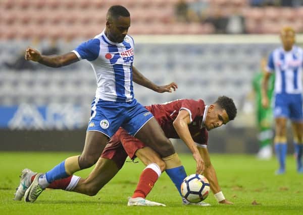 Liverpool's Dominic Solanke battles with Wigan's Gavin Massey during the pre-season friendly at the DW Stadium