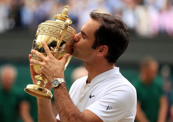 Roger Federer kisses the men's singles trophy at Wimbledon