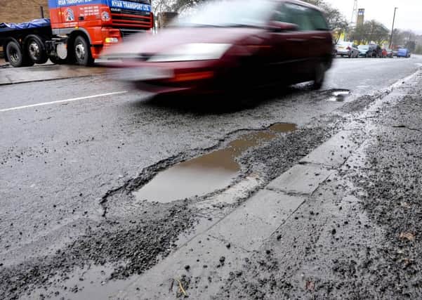 A car driving around a pothole