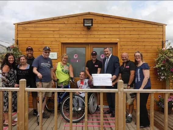 Maximus chief executive Robert Winter presents the bike workshop project grant to My Life Legacy's CEO Caroline Tomlinson plus members and supporters
