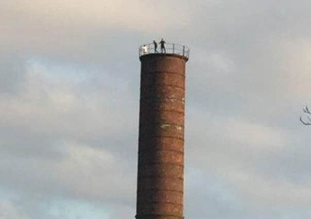 Youths on the top of a chimney at the Pagefield building