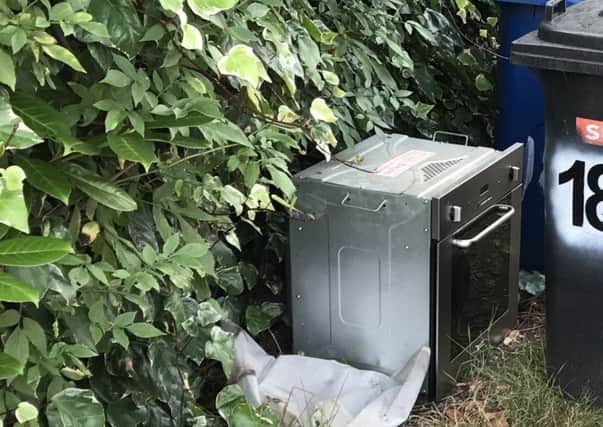 Bins left in an alleyway and fly-tipped items on Bolton Road, Ashton