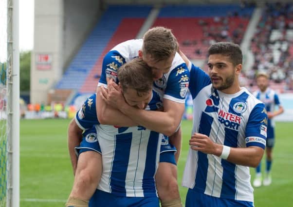 Nick Powell is congratulated on one of his two goals at the DW Stadium yesterday