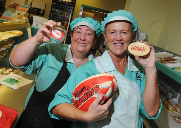 Galloways Bakery staff, from left, Jane Molyneux and Julie Hewitt from Gidlow Lane, Wigan, with some of the sweet treats showing their support for Wigan Warriors ahead of the Challenge Cup final