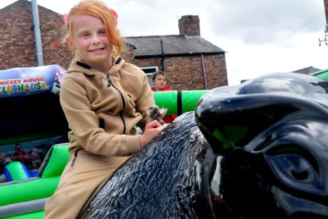 Eight-year-old Caitlin Disley rides the bucking bronco at the Beech Hill fun day