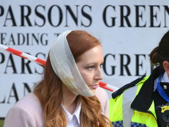 An injured woman is assisted by a police officer close to Parsons Green station in west London after Scotland Yard declared a terrorist incident following a blast