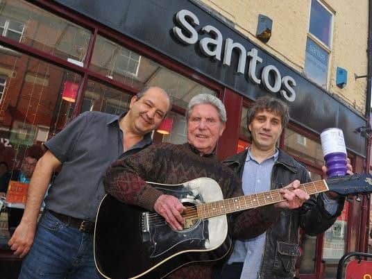 Cafe owner Ash Sherafatian, musician Mike Gannon and sound engineer Paul ONeill outside the Santos Cafe in Mesnes Street, which has inspired the Sixties rockers charity single in aid of Kidscan