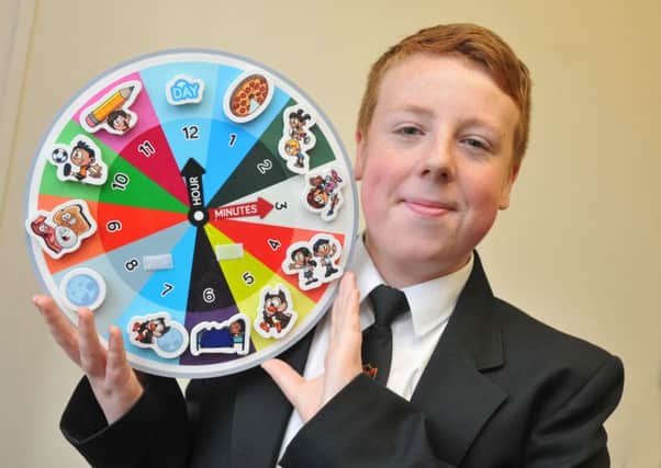 Jacob Higham with the prototype of his special clock, to aid youngsters and people with autism