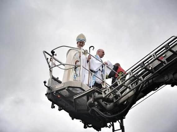 Bishop of Bolton Mark Ashcroft and St Stephens vicar Rev Martin Cox hoisted aloft by the fire brigade
