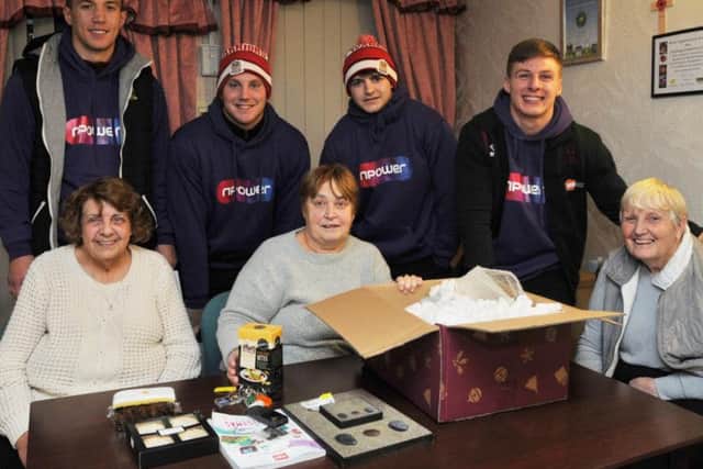 Wigan Warriors players visit residents at Thornburn House, Norley Hall, Wigan, to sweep up leaves and clean up paths