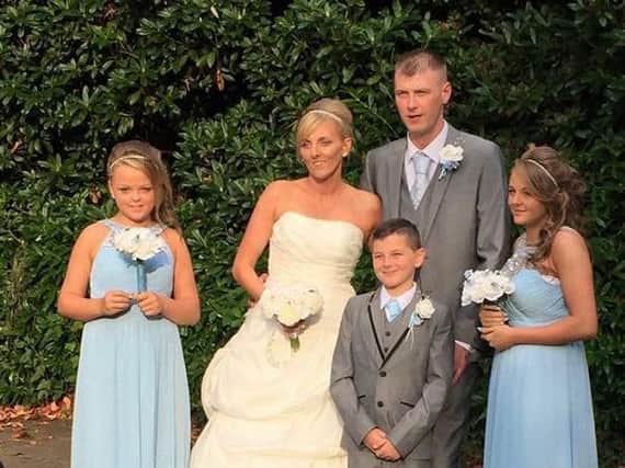 Childhood sweethearts Damian and Karen Hennefer and her three children on their wedding day in October 2015