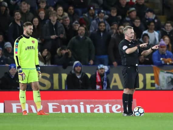 Jon Moss awards Leicester's second goal after consulting VAR.