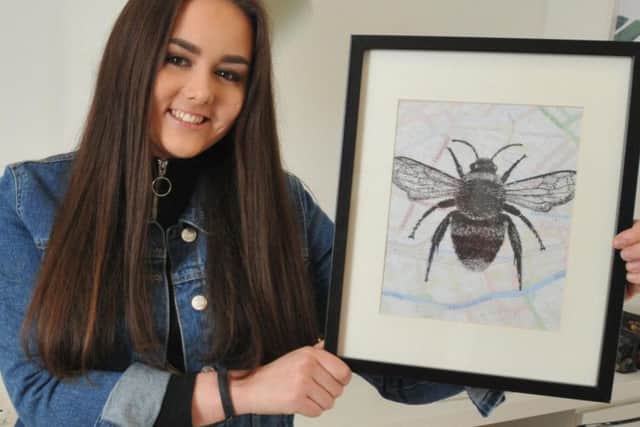 Orrell artist Charlotte Jeacock with her print of a Manchester Bee penned onto a map of the city