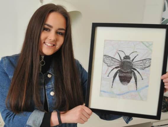 Orrell artist Charlotte Jeacock with her print of a Manchester Bee penned onto a map of the city