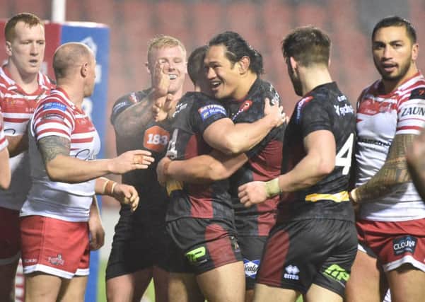 Wigan players celebrate a try during their win over Leigh