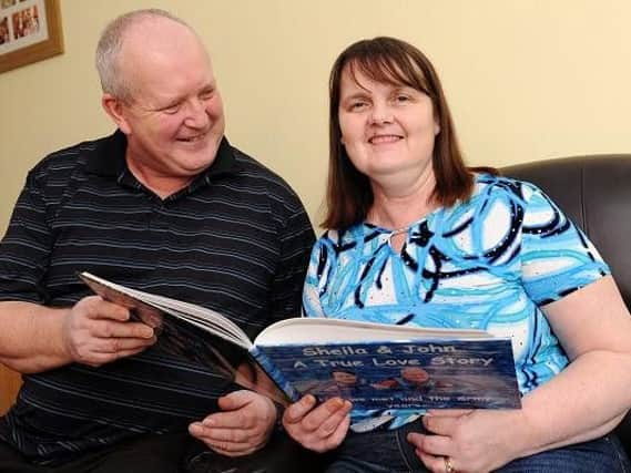 John and Sheila Bell reading one of the bespoke books created to help her remember