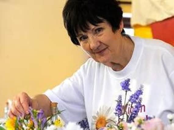 Kathleen Aspinall with some of the flower displays she made for sale