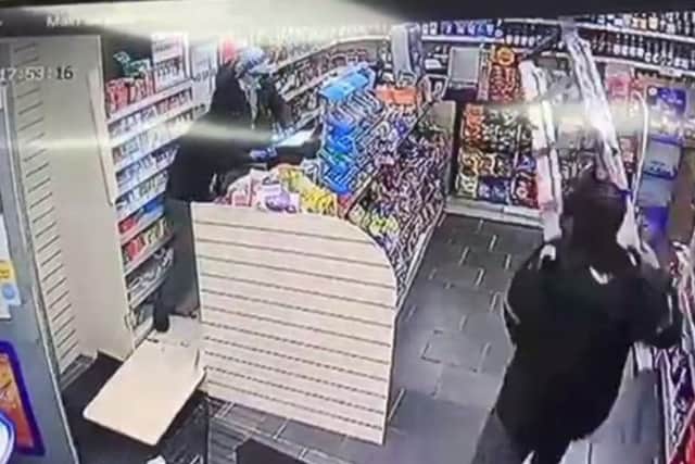 CCTV footage shows the store worker fending the robbers off with step ladders