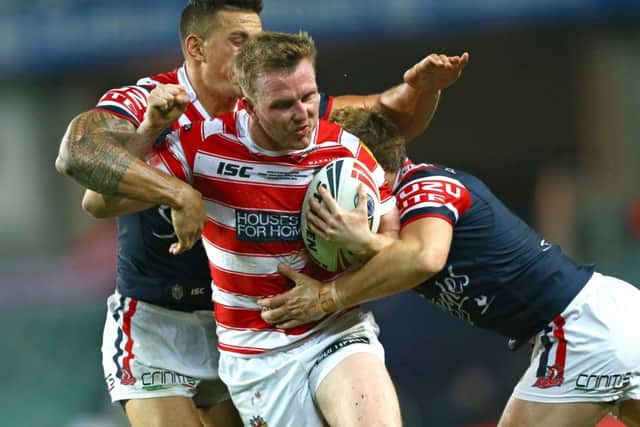 Dan Sarginson is tackled by Sonny Bill Williams during the 2014 World Club Challenge Sydney Roosters v Wigan Warriors