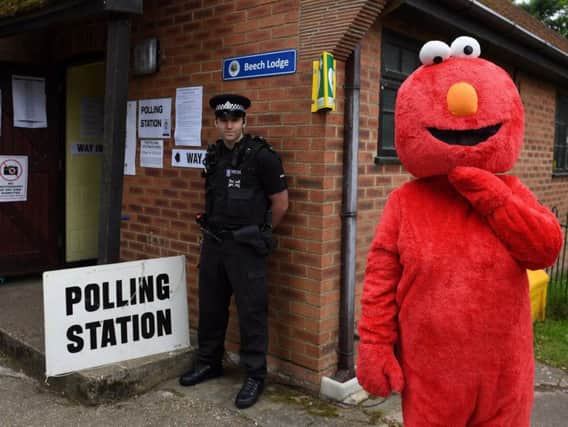Police and a man dressed as Elmo outside a polling station
