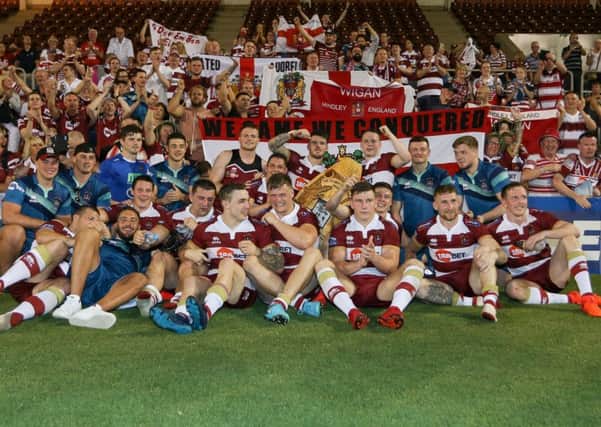 Wigan players pose for a picture with some of the travelling fans