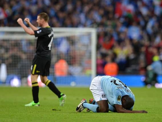 Wigan's James McCarthy celebrates the final whistle at Wembley in 2013 as City's Yaya Toure slumps to the ground