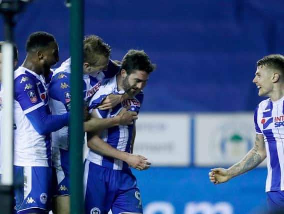 Will Grigg is mobbed by team-mates