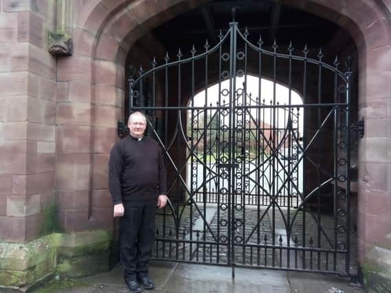 Reverend Andrew Holliday at the Peace Gate at St Wilfrid's Church, Standish, which is closed due to vandalism