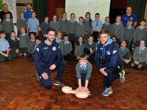 Players Will Grigg, left, and Michael Jacobs, right, were surprise guests to help Year Six pupils with CPR training