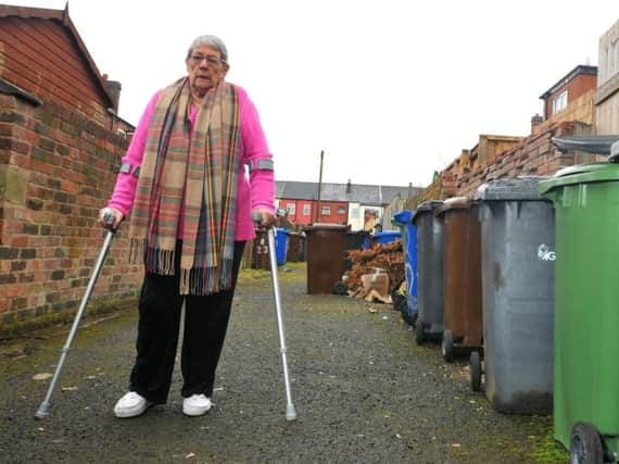 Pauline in the alleyway where rubbish piles up