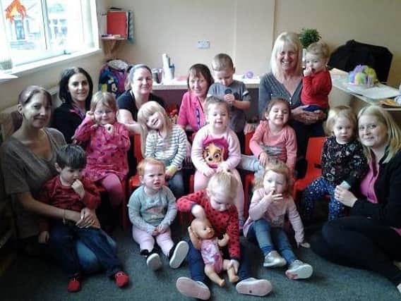 Nursery staff and children celebrate the new report