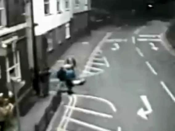 The victim lies unconscious in the street after the assault