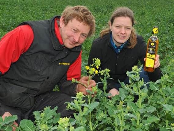 John and Clare Wignall in a rapeseed field, at Wignalls Farm